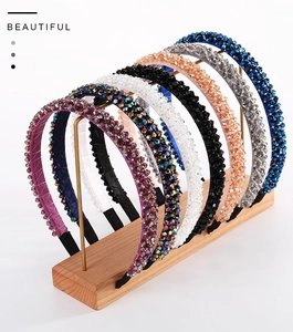 Detail of seven handmade crystal beaded headbands in various colors on a metal display stand