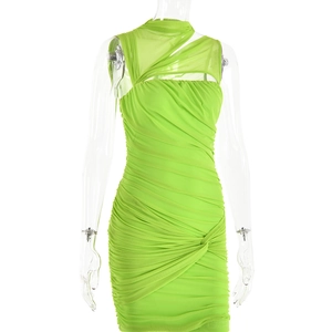 Détail de la robe en maille vert néon avec tissu froncé et découpe latérale