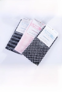 Close-up of three exfoliating body towels in striped and checkered patterns in packaging