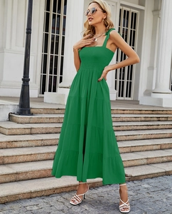 Detail of green tiered maxi dress showing smocked bodice and layered ruffle skirt texture