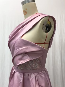 Detailed close-up of pink one-shoulder satin gown with silver sequin floral lace on the waist