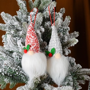 Paar leuchtende Weihnachtszwerge mit Strickmützen an einem verschneiten Tannenbaumzweig