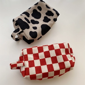 Detail of cow print and checkerboard velvet cosmetic bags with thick corduroy texture