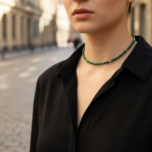 Elegant natural green malachite beaded necklace with gold accents on female model