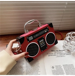 Detail of red vintage radio-style handbag featuring silver handle and speaker patterns