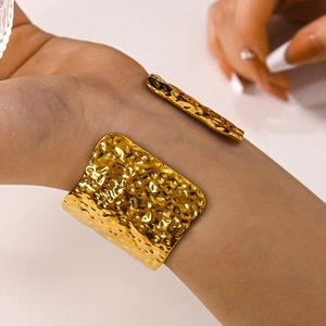 French retro wide hammered gold V-shape open cuff bracelet worn on female wrist