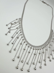 Macro shot of silver tassel necklace with multiple bead chains and adjustable clasp detail