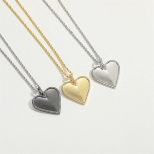 Luxurious heart pendant necklaces with textured gold, silver and black metal finishes