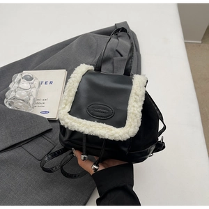 Detail of black PU leather backpack with white faux fur trim and drawstrings