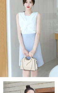 Detail of a beige handbag with a metallic handle held by a model in a summer outfit