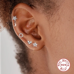 925 Sterling Silver earring set featuring star, moon, and heart studs on a female model