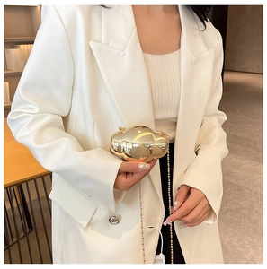 Chic gold metallic cloud-shaped shell bag with elegant chain strap shown on model
