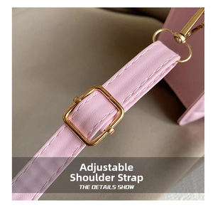 Detail of adjustable pink faux leather shoulder strap with gold metal buckle and stitching