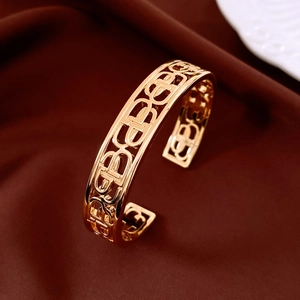 Detail of 18K gold plated hollow cuff bracelet with geometric patterns on silk