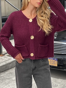 Détail d'un cardigan en maille bordeaux avec texture épaisse et boutons dorés chics