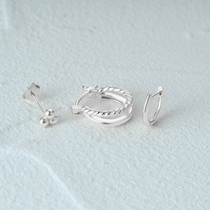 Detailed macro view of 925 sterling silver earring set including studs and hoops