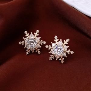 Detailed view of gold plated snowflake stud earrings featuring sparkling zircon stones