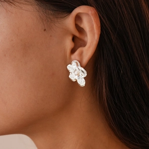 Minimalist silver flower stud earrings with hammered metal texture and white pearl accents