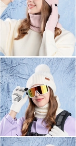 Detailed view of knitted winter set including pom-pom hat, scarf and warm gloves
