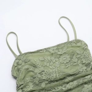 Close-up of light green lace neckline and delicate strap detail on a slim-fit dress