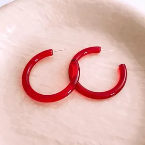 Minimalist red resin C-shaped hoop earrings with silver pins for a modern luxury style