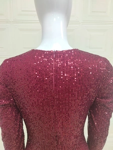 Détail du dos de la robe à paillettes bordeaux avec fermeture éclair et texture brillante