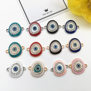 Macro detail of colorful enamel evil eye charms with rhinestones and metal loops