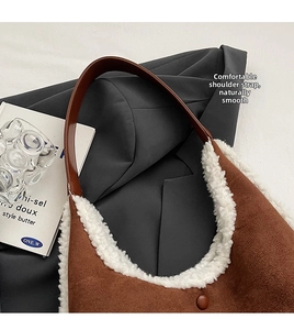 Detail view of brown suede tote bag with white faux fur trim and sleek leather strap