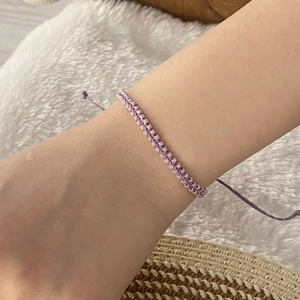 Detail of light purple bead woven bracelet on wrist with a bohemian handmade style