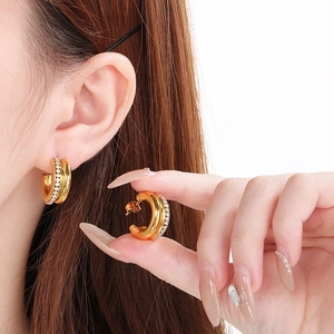 Vintage gold C-shaped earrings with sparkling rhinestones shown on model for elegant look