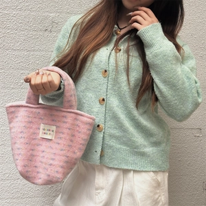 Close-up of pink plush tote bag featuring colorful specks and a white brand label