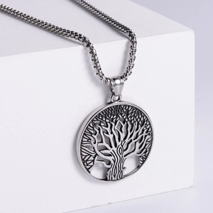 Minimalist silver stainless steel Tree of Life pendant necklace on a white geometric stand