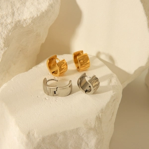 Wide textured 18K gold and silver stainless steel hoop earrings on minimalist stone