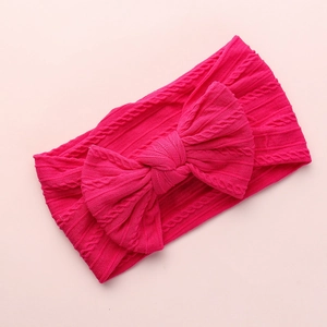 Macro detail of the rose red cable knit texture and soft bow on the infant nylon headband