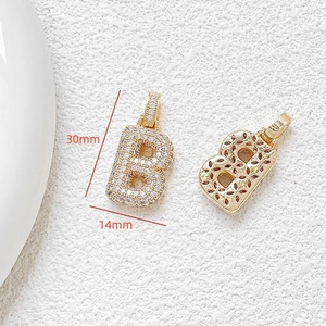 Macro detail of gold letter B pendant with cubic zirconia inlay 30mm x 14mm size