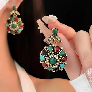 Vintage style colorful crystal floral drop earrings in aged gold finish on model