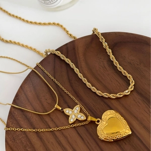 Parure de trois colliers en titane plaqué or 18K avec médaillon cœur et pendentifs strass fleur
