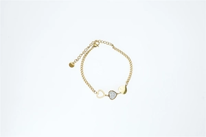 Detail view of gold heart bracelet featuring openwork, pave zircon, and solid heart charms
