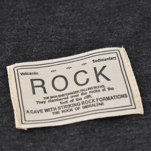 Dettaglio di un berretto in maglia grigio scuro con etichetta in cotone bianco tipo rock