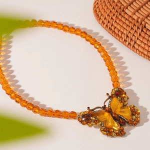 Detailed close-up of retro amber butterfly necklace with crystal rhinestones