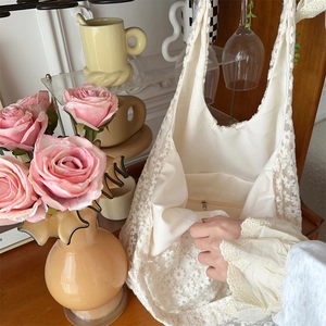 Lace embroidery shoulder bag showing floral texture and zipper pocket on aesthetic background