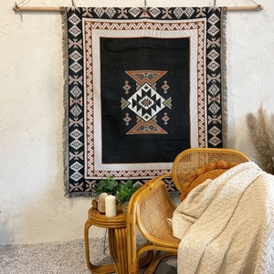 Detail of bohemian geometric woven blanket with tassels used as a wall hanging tapestry