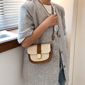 Bohemian woven saddle bag with brown faux leather and golden buckle shown on a model