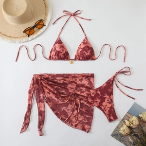 Detail of a 3-piece floral bikini set featuring a hibiscus print and matching mesh sarong