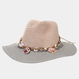Detail of straw hat featuring sea shells decor and contrasting pink and grey woven textures