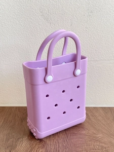 Detail of purple EVA beach bag with holes, durable white rivet and non-slip bottom texture