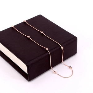 Detail shot of rose gold bead snake chain necklace on a jewelry display box