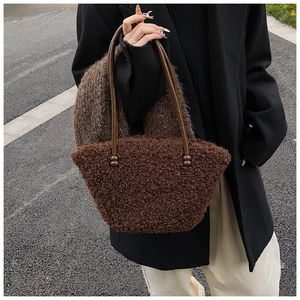 Détail du sac à main en peluche marron foncé avec fines lanières en cuir et perles