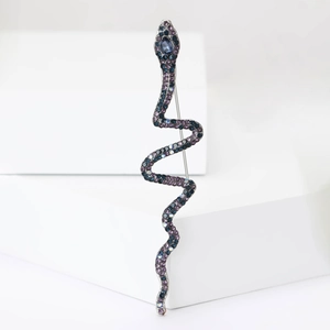 Macro detail of luxury snake brooch with gradient blue purple crystals and large gemstone