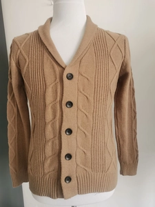 Nahaufnahme der warmen kamelfarbenen Strickjacke mit Reverskragen und Zopfmustermaterial